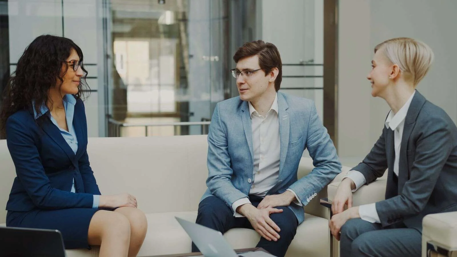 Three professionals discussing plans in a modern office